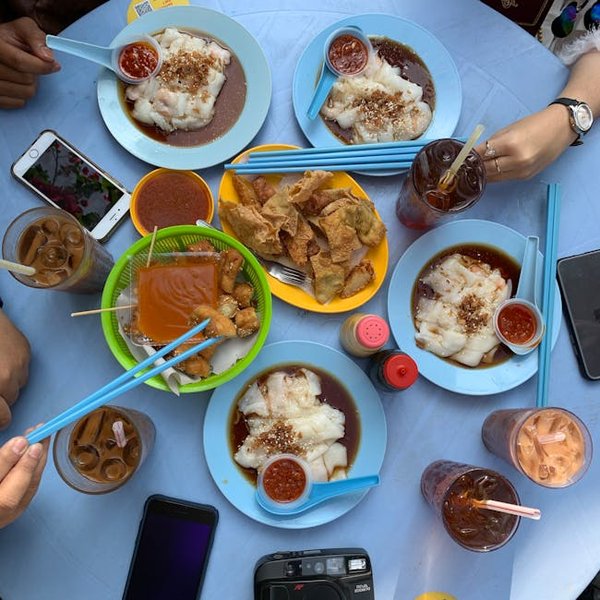 A traditional Nasi Lemak plate with coconut rice, fried chicken, sambal, peanuts, and a boiled egg