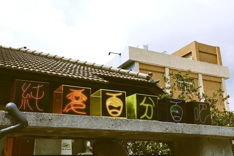 A vibrant street scene on Jalan Pantai Cenang at dusk, with glowing restaurant signs, crowds of people, and the silhouette of palm trees